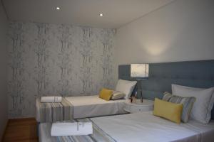 a bedroom with two beds and a lamp in it at Quinta do Perguntouro in Barrosas +35 photos