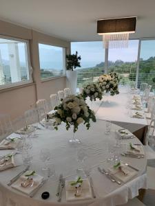 a dining room with a long table with flowers and glasses at La Collina dei Colori in Vasto