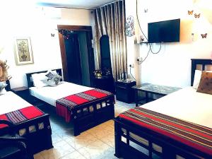 Cette chambre comprend deux lits et une télévision. dans l'établissement Joseph Family Villa, à Negombo