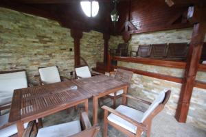 a room with a table and chairs and a brick wall at Къща за гости Джая in Belogradchik