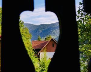 a view of a house through a window at Casa Ursu in Cârțișoara