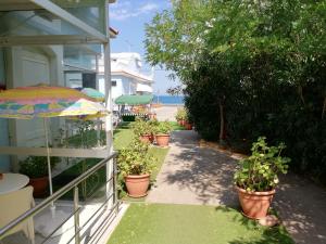 een patio met potplanten en een parasol bij Homely Studios in Chios