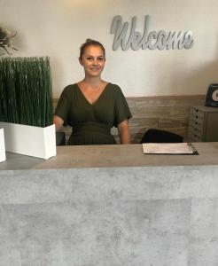 a woman is standing behind a counter in a office at Central Hotel Duisburg in Duisburg