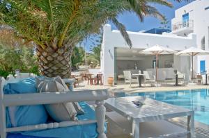 a villa with a palm tree and a pool at Dilino Hotel Studios in Agios Prokopios