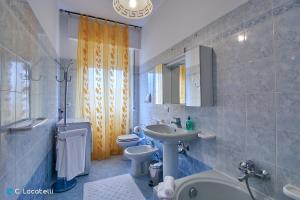 a bathroom with a sink and a toilet and a bath tub at Casa della nonna in Abbadia Lariana