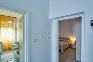 a bedroom with a bed and a door leading to a bathroom at Casa della nonna in Abbadia Lariana