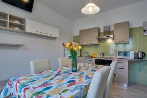 a kitchen with a table with a vase of flowers on it at Casa della nonna in Abbadia Lariana