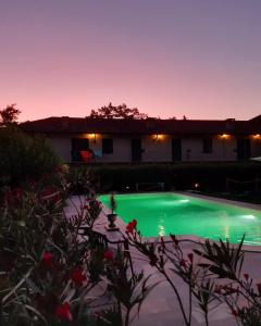 una piscina por la noche con una casa en el fondo en La Cascina Del Castello, en Asti