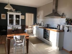 cocina con armarios blancos y mesa de madera en Seeblick Cottage, en Ziemitz