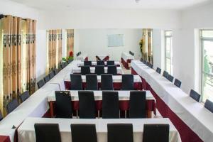 una sala de conferencias con mesas, sillas y ventanas en Bilkon Hotel Jinja, en Jinja
