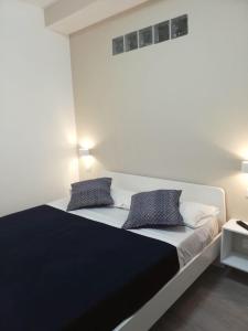 una camera da letto con un grande letto con due cuscini di Cosmo Rooms a pochi passi da Tropea a Santa Domenica