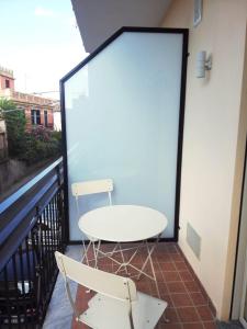 a white table and two chairs on a balcony at Cosmo Rooms a pochi passi da Tropea in Santa Domenica