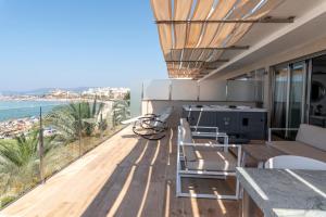 a patio area with chairs, tables, and a balcony at Apartaments Delfin in Playa de Palma