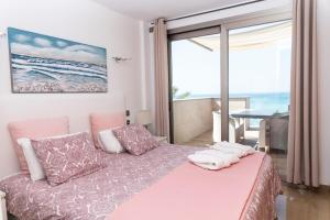 a bedroom with a bed with a view of the ocean at Apartaments Delfin in Playa de Palma