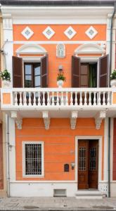 an orange and white building with a balcony at Le dimore sul mare in Porto Recanati