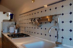 a kitchen with a sink and a stove and tiles at Attico Capparozzola in Venice