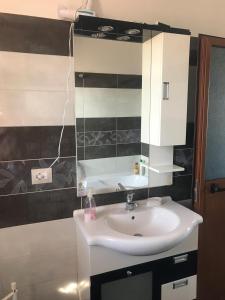 un bagno con lavandino e specchio di SARA'S VILLA a Shkodër