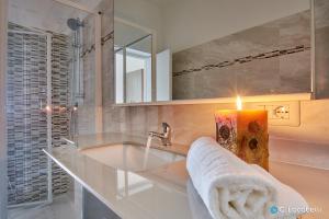 a bathroom with a sink and a mirror and a candle at Casa della nonna in Abbadia Lariana