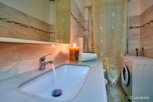 a bathroom with a sink and a washing machine at Casa della nonna in Abbadia Lariana