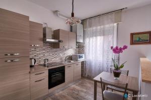 a kitchen with a table with purple flowers on it at Casa della nonna in Abbadia Lariana