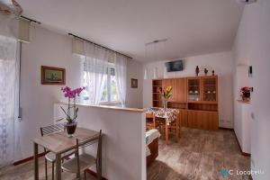 una cucina e un soggiorno con tavolo e sedie di Casa della nonna ad Abbadia Lariana
