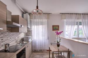 a kitchen with a table with purple flowers on it at Casa della nonna in Abbadia Lariana