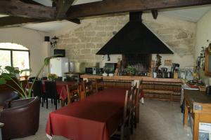 a restaurant with a table and chairs and a kitchen at Chambre Foret du Mas des Fontaines in Montagnac