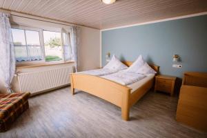 HaundorfにあるStixenhof - Ferienwohnung Heidi Nehmeierのベッドルーム1室(木製ベッド1台、窓付)