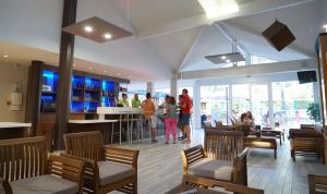 ein Restaurant mit Leuten, die um eine Bar stehen in der Unterkunft VVF Landes Moliets in Moliets-et-Maa