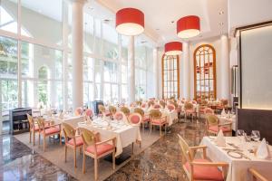 a dining room with tables and chairs and large windows at Grupotel Parc Natural & Spa in Playa de Muro