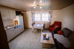 a kitchen and a living room with a table and a kitchen at Stixenhof - Ferienwohnung Heidi Nehmeier in Haundorf