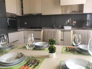 a kitchen with a table with plates and wine glasses at SARA'S VILLA in Shkodër