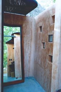 Habitación con ventana y pared de ladrillo en Bufo Alvarius en Tulum