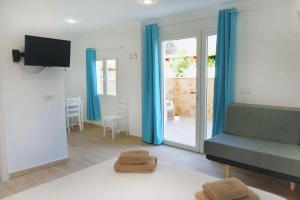 カラ・フィゲラにあるApartamentos Vistalmar Mallorcaのリビングルーム(青いカーテン、ソファ付)