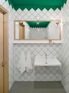 een badkamer met een wastafel en een spiegel bij Kitz Boutique Hotel & Restaurant in Metzingen