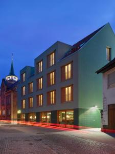 a building with lights on in a city at night at Kitz Boutique Hotel & Restaurant in Metzingen