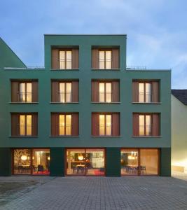 a green building with a lot of windows at Kitz Boutique Hotel & Restaurant in Metzingen