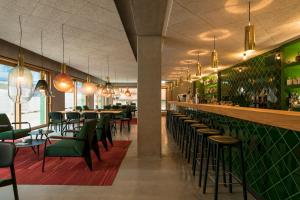 a restaurant with green chairs and a bar at Kitz Boutique Hotel & Restaurant in Metzingen