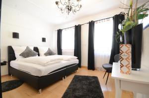 a bedroom with a black and white bed and a desk at Hotel Da Felice in Bopfingen