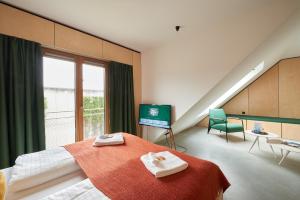 a bedroom with a bed with two towels on it at Kitz Boutique Hotel & Restaurant in Metzingen