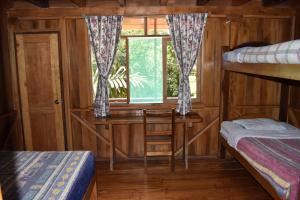 a room with two bunk beds and a window at El Descanso in Mindo