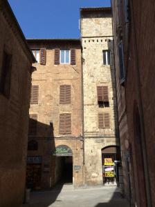 ein altes Backsteingebäude mit einem Torbogen in einer Gasse in der Unterkunft Albergo Cannon d'Oro in Siena