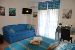 un soggiorno con un divano blu e un tavolo di B&B Due Fontane a Caltanissetta