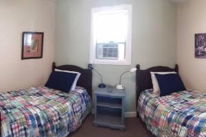 2 camas individuales en una habitación con ventana en Wildwoof Beach Bungalow @ NW. 3 Blocks to Beach! en North Wildwood