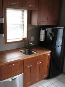 a kitchen with a sink and a black refrigerator at Wildwoof Beach Bungalow @ NW. 3 Blocks to Beach! in North Wildwood