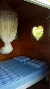 a bed in a boat with a heart window at CABANE au Soleil by in Saint-François