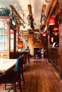 a dining room with tables and chairs and a fireplace at Prince Arthur in London