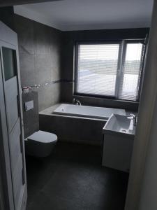 a bathroom with a sink, toilet and bathtub at Apartamenty Południowa in Szczecin
