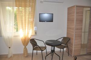 Zimmer mit einem Tisch und Stühlen sowie einem TV in der Unterkunft Villa Rahal in Racalmuto