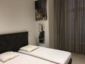 カンヌにあるViva Riviera - 4 Bedrooms 2 Bathrooms Cannesのベッド(白いシーツ、黒いヘッドボード付)
